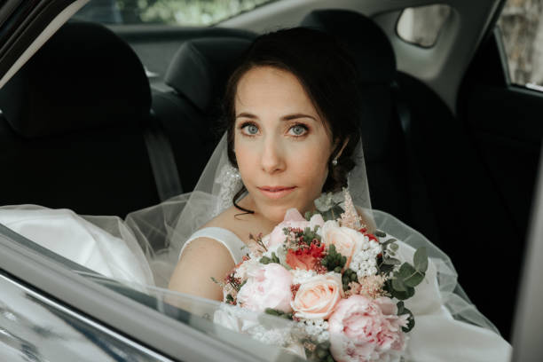 istock bride sits in the car on your wedding. bride in a car window 1151253828