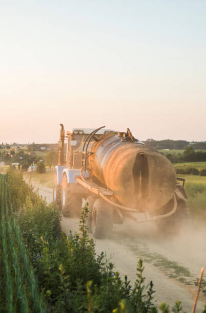 istock A blue tractor with a tank rides along a road in a wheat field. 1151256069