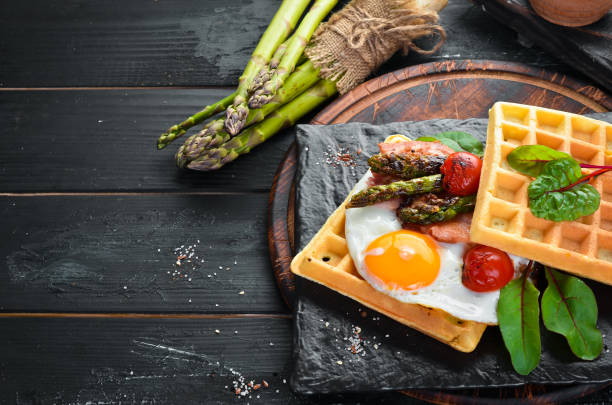 istock Breakfast. Belgian waffles with egg, asparagus and bacon. Healthy food. Top view. Free space for your text. 1151259310