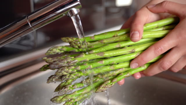 Close-up of Adult Woman Washing Asparagus