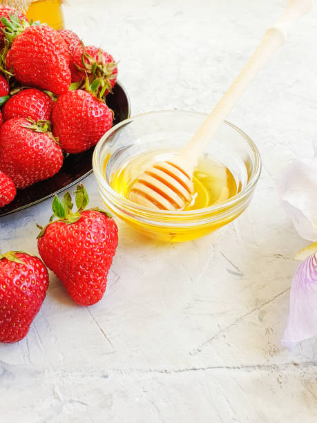 istock fresh strawberries on a plate, honey, iris flower on a gray concrete background 1151264002