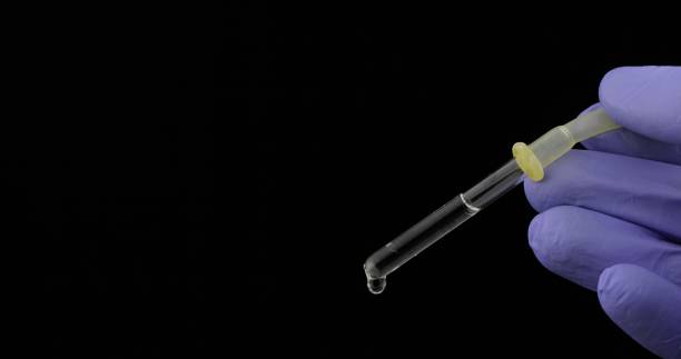 istock Hand in medical glove drip drop from pipette. Close-up video. Liquid drop 1151264287