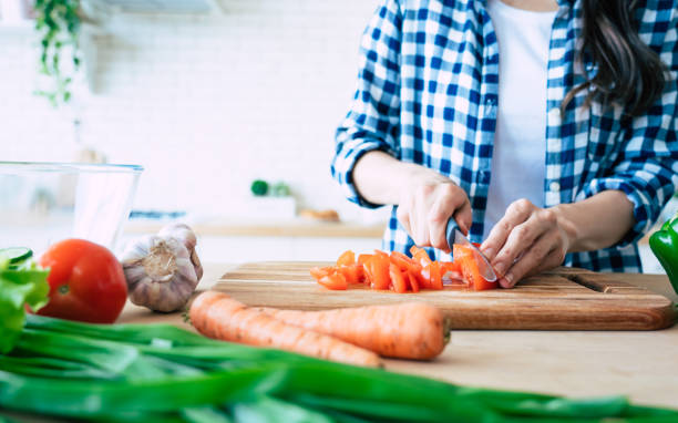 istock Female hands is cutting peppers for salad on the table in kitchen. 1151268654