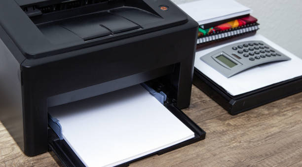 istock Laser printer and office supplies on the table. 1151277726