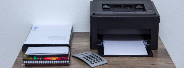 istock Laser printer and office supplies on the table. 1151277937