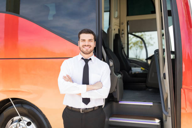 Proud Bus Driver Smiling With Hands Folded Portrait of good looking driver standing arms crossed outside intercity bus intercity train photos stock pictures, royalty-free photos & images