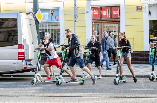 Group of people with electric push scooter in Prague during day of springtime