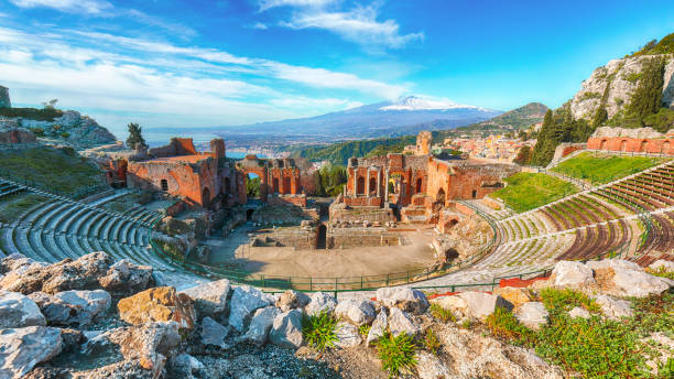 Taormina Ruins of ancient Greek theater in Taormina and Etna volcano in the background. Coast of Giardini-Naxos bay, Sicily, Italy, Europe. sicily stock pictures, royalty-free photos & images