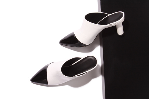 Black and white fashion mules on black and white background