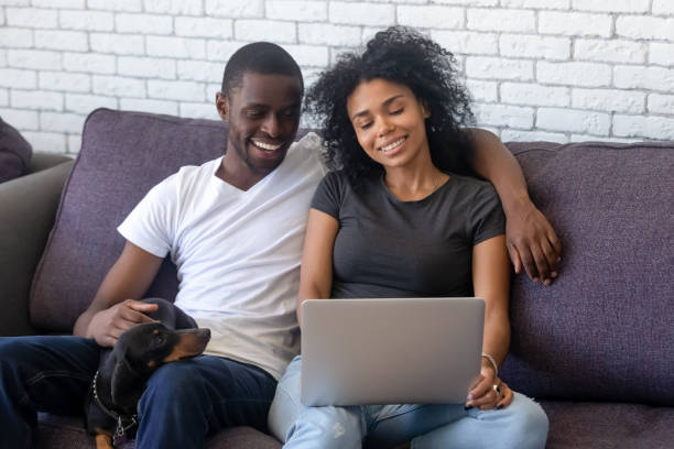 istock Happy black couple using laptop relaxing with pet at home 1151287208