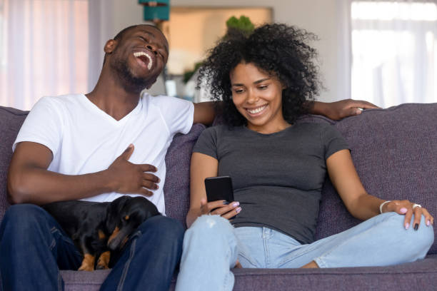 istock Young black couple with pet have fun watching video online 1151287219