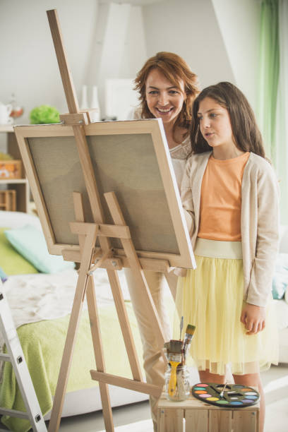 istock Mother and daughter enjoying while painting 1151287502