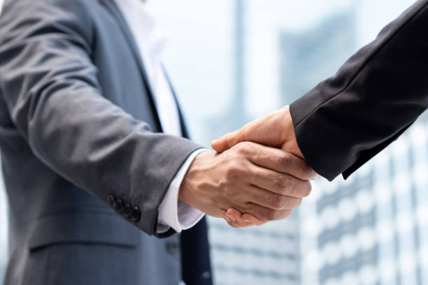istock Businessmen making handshake in the city 1151287644
