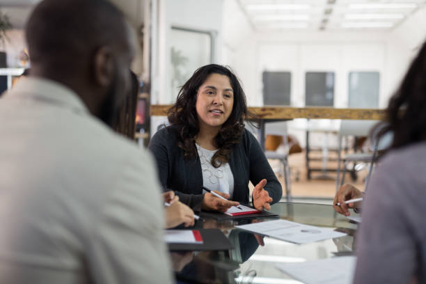istock Female CEO leads a team meeting at the conference table 1151287729