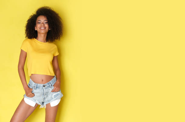 istock Black woman in yellow clothes on studio shoot. 1151289354