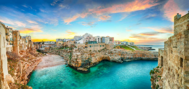 Cala Paura gulf with Bastion of St. Stephen Sunset at Cala Paura gulf with Bastione di Santo Stefano and Lama Monachile beach in background. Polignano a Mare, Apulia, Italy, province of Bari. puglia beach stock pictures, royalty-free photos & images