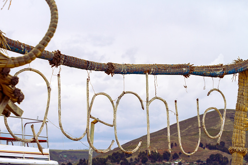 Hanging sign made with totora with the word Quechua on the island of Uros, Peru