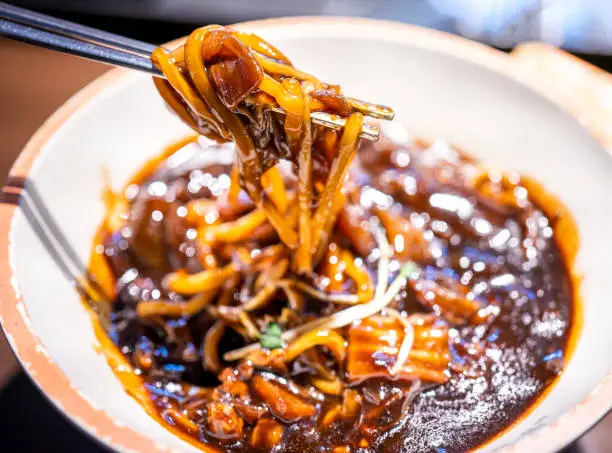 Photo of Jajangmyeon, jjajangmyeon, fried sauce noodle, delicious korean traditional noodles cuisine with korea black bean paste sauce, close up, copy space