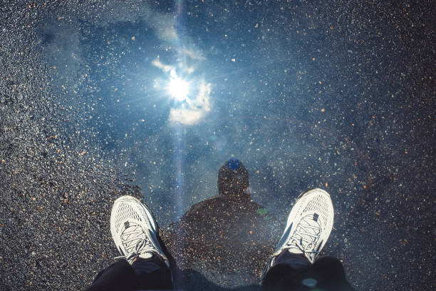 男の影、星明かり、日光の反射水溜りのシルエット - isolated despair hope assistance ストックフォトと画像