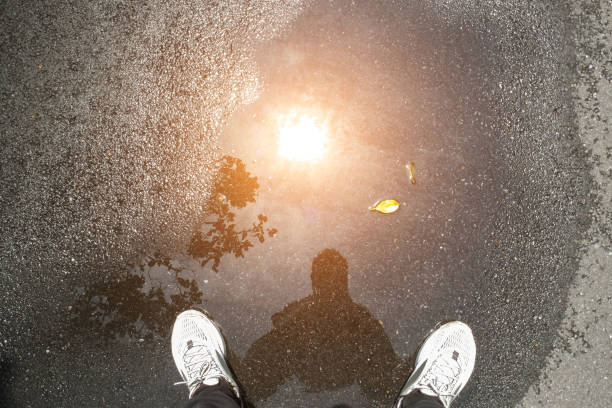 男の影、星明かり、日光の反射水溜りのシルエット - isolated despair hope assistance ストックフォトと画像