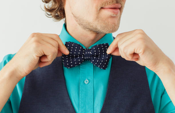 istock Young fashion hipster correcting his bowtie 1151314185