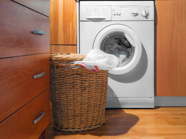 istock Large Wicker Laundry Basket, Open Lid Near the Washing Machine with Laundry. House Interior Laundry Room. Wood Interior Design. 1151320002