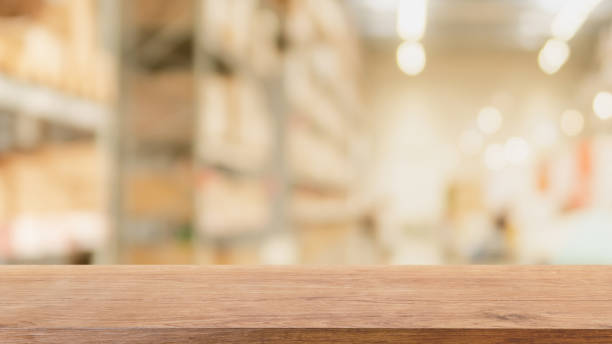 istock Empty wood table top and blurred bokeh warehouse interior space  background - can used for display or montage your products. 1151321893