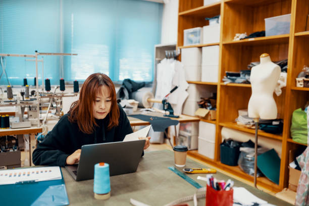 istock Mid adult design professional working at a computer in a textile factory 1151328177