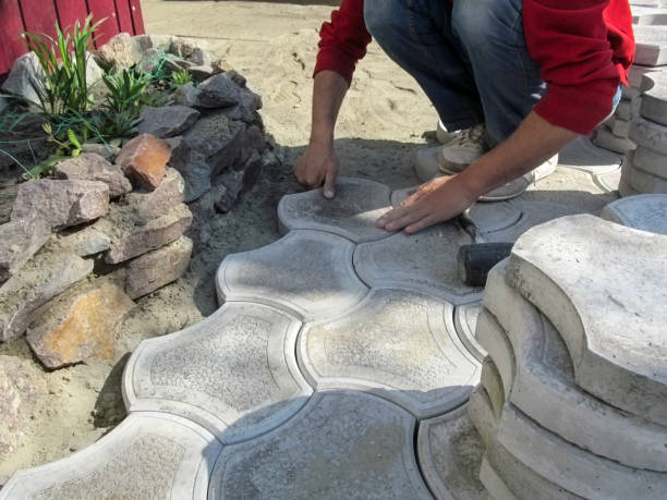 istock Worker by his hands lays figured paving tiles around a flower bed, background with copy space 1151329581