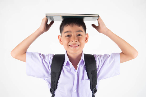 istock Little Asian boy in student uniform on white background 1151330635