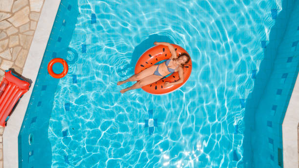 istock Woman sunbathing on inflatable watermelon ring in the pool 1151331316