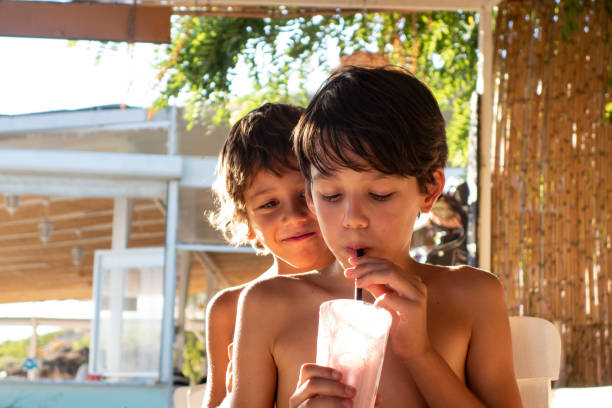 istock Brother Boys drinking milkshake cocktail on beach 1151334858