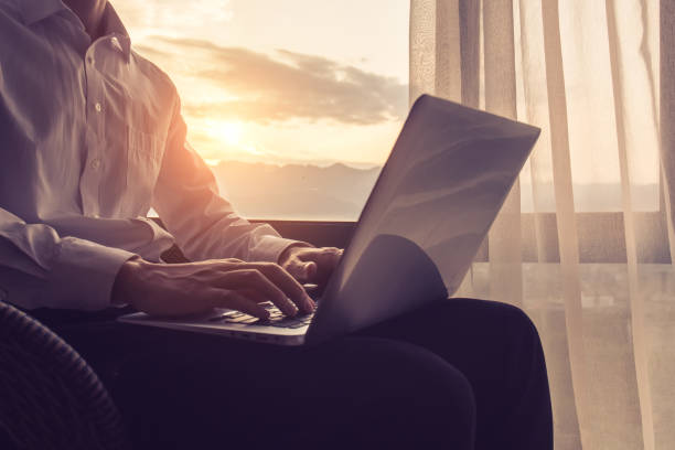 istock Businessman sitting and using laptop by window 1151336858