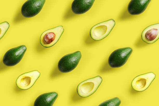 istock Avocado pattern on yellow background. Pop art design, creative summer food concept. Green avocadoes, minimal flat lay style. Top view 1151342580