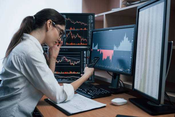 istock Great ideas starts from small rooms. Woman working online in the office with multiple computer screens in index charts 1151342851