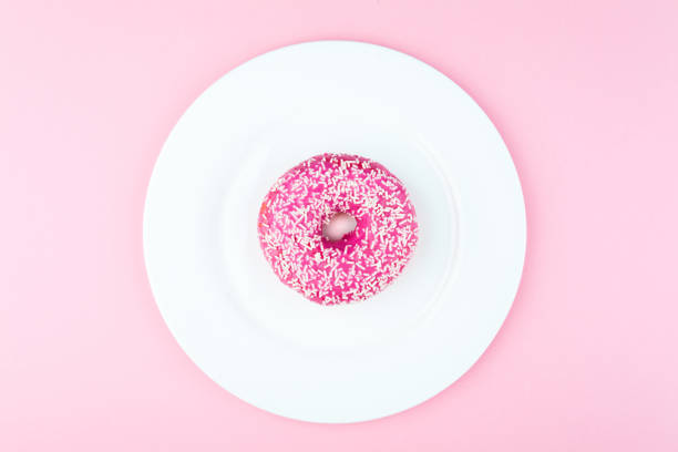 istock Pink round donut at bright pink background 1151342931