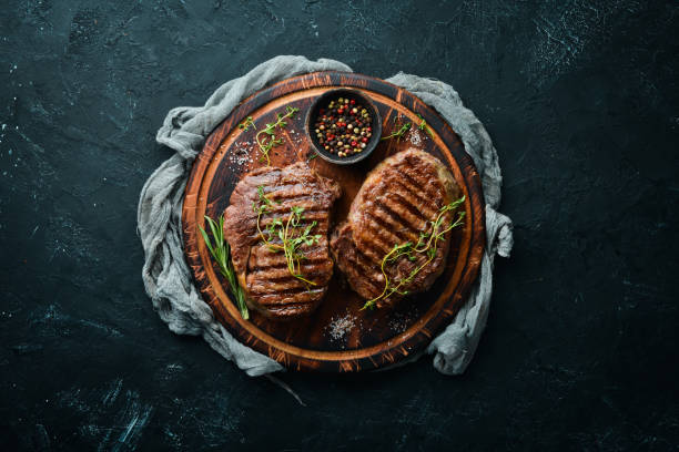 istock Grilled beef steak medium rare on a black stone table. Top view. Free space for your text. 1151347215
