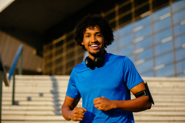 istock Young runner resting and listening to music outdoors after workout 1151348430