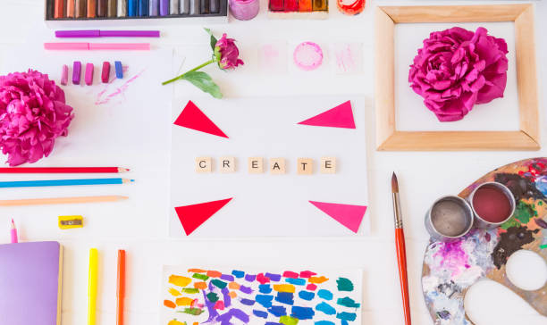 istock Top view creative artist workplace. Blank canvas with Create word lettering, variety of painting supplies and peony flowers. Drawing, inspiration, craft, creativity concept. Art therapy. Flat lay. 1151353341