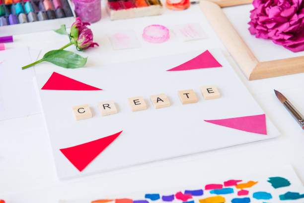 istock Side view close up creative artist workplace. Blank canvas with Create word lettering, variety of painting supplies and peony flowers. Drawing, inspiration, craft, creativity concept. Art therapy. 1151353361