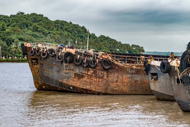 navi alimentatori dismessa generalmente conosciute come chiatte, spiaggiate a ship breaking yard. un tempo utilizzati per il trasporto di rinfuse su navi madre, sono ora obsoleti a causa della recessione globale e del divieto minerario. - shipwreck beach old obsolete foto e immagini stock