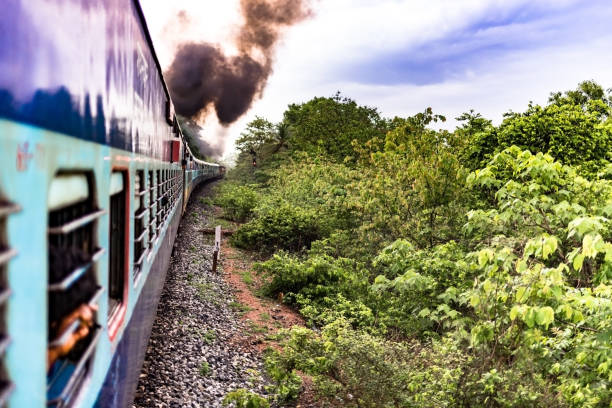 ディーゼルエンジンによって描かれたインド国鉄列車の美しい写真, 雨季に緑豊かな森林地帯を通過しながら、煙を放出します. - travelogue ストックフォトと画像