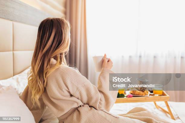 Beautiful Woman Laying And Enjoying Breakfast In Bed Stock Photo - Download Image Now
