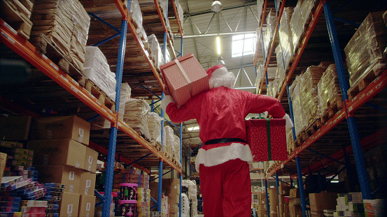 Santa in the warehouse. Picking up christmas gifts