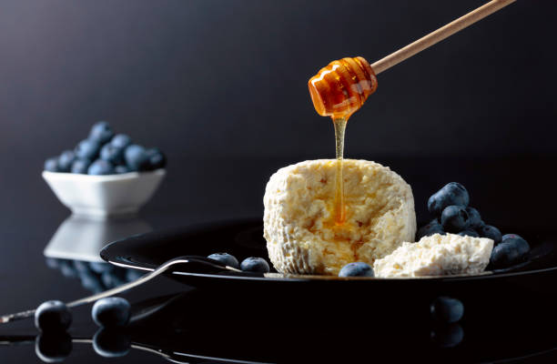 istock Cottage cheese with honey and blueberry on a black plate. 1151360751