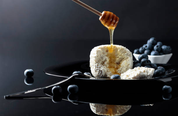 istock Cottage cheese with honey and blueberry on a black plate. 1151360754