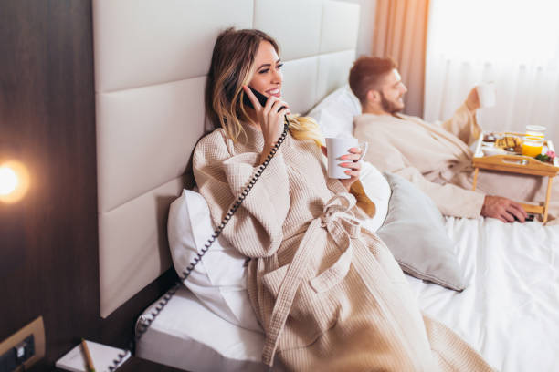 Woman calling room service for food from hotel room Woman calling room service for food from hotel room room service stock pictures, royalty-free photos & images