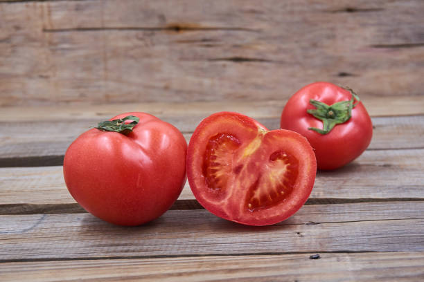istock Tomato  isolated on wood background. 1151362047