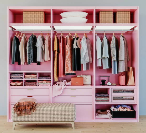 modern pink wardrobe with clothes hanging on rail in walk in closet design interior, 3d rendering stock photo