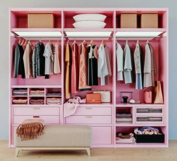 Photo of modern pink wardrobe with clothes hanging on rail in walk in closet design interior, 3d rendering